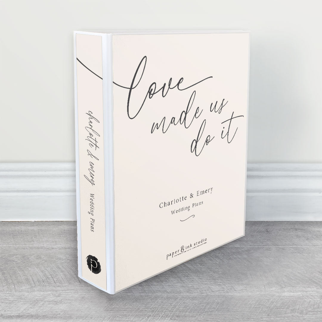 A wedding planner, guide and organiser in a modern romantic design that says Love made us do it with charcoal grey text on a neutral nude beige background