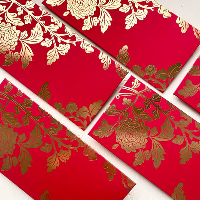 A picture showing layered red envelopes with the front facing up, showing the Peony design by Paper and Ink Studio. The design is metallic gold foil on rich lacquer red coloured envelopes.