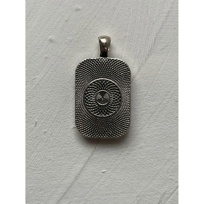 A memorial pendant or memorial charm in the design called Rectangle Memorial Photo Pendant, showing the back of the memorial charm. The pendant is shown on a white neutral textured background and is intended to be tied to a wedding bouquet with ribbon or hung from a chain to wear, to include a deceased relative on your wedding day.
