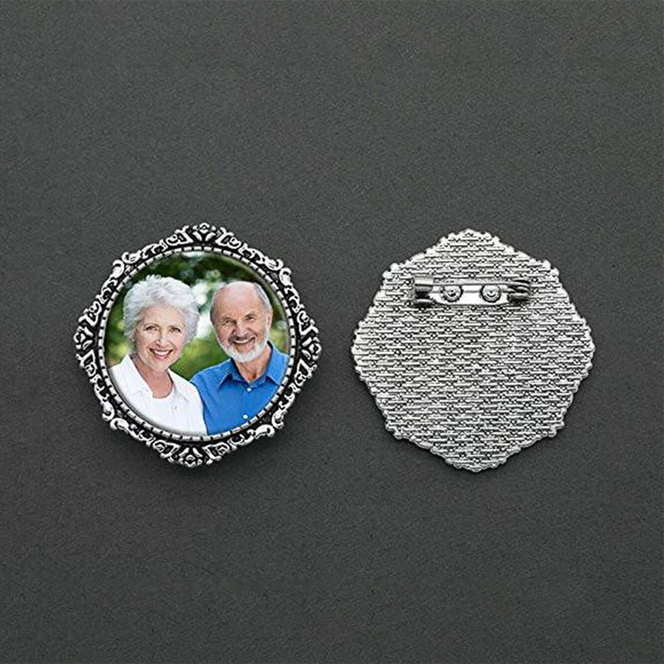 A memorial brooch or memorial pin in the design called Lace showing a photo of a grandfather and grandmother, with the back of the pin showing the closure next to it. The pin is show on a neutral black background and is intended to be pinned to a wedding bouquet or wedding jacket to include a deceased relative on your wedding day.