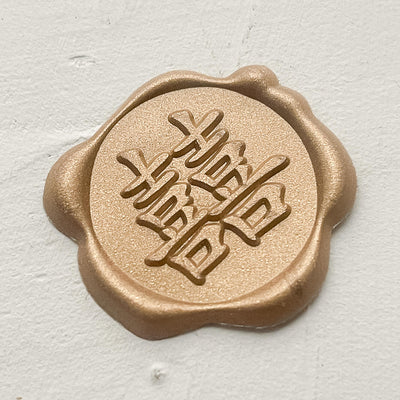 A gold wax seal showing Chinese calligraphy for Double Happiness, sold together with a packet of 10 red envelopes or ang pao or hongbao.