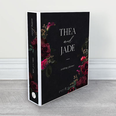 A wedding planner, guide and organiser in a moody floral design with magenta, burgundy and pink flowers and dark emerald green leaves on a black background