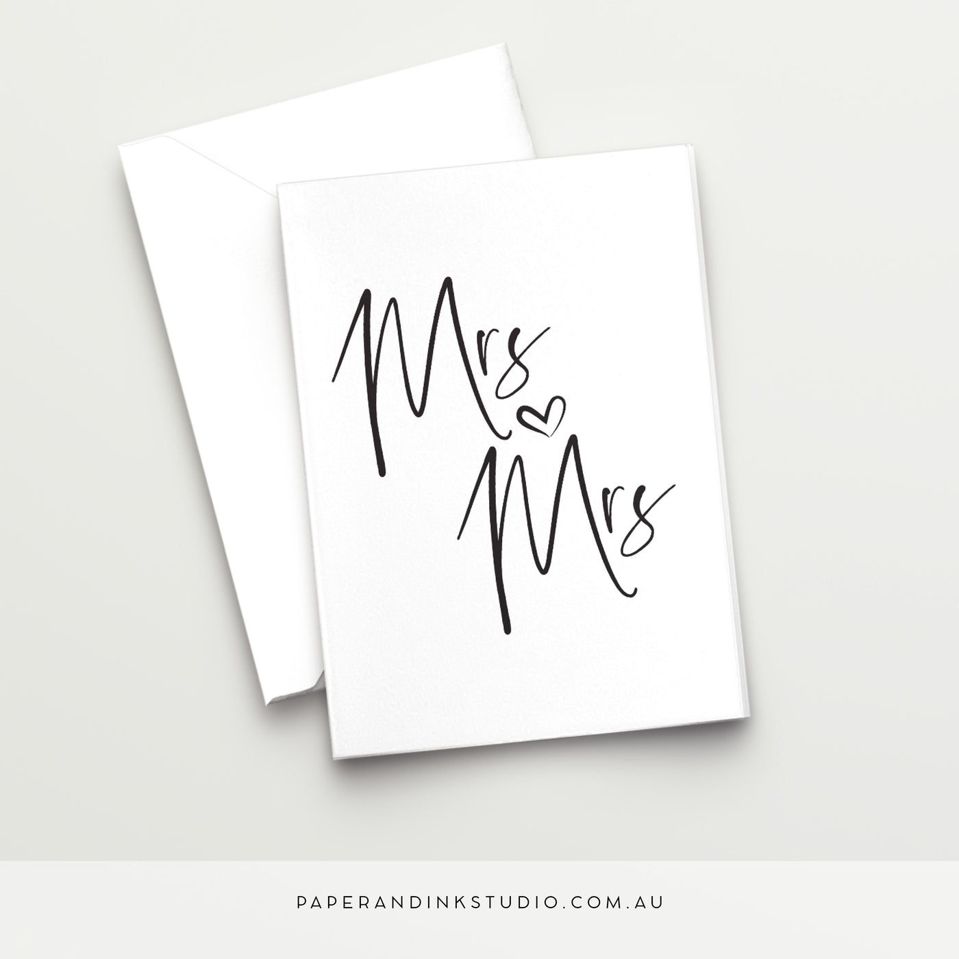 A white folded wedding card in a design called Thorne with black writing that says Mrs and Mrs with a love heart between, in a beautiful handwritten font, to give to two brides as a same-sex wedding card on their wedding day